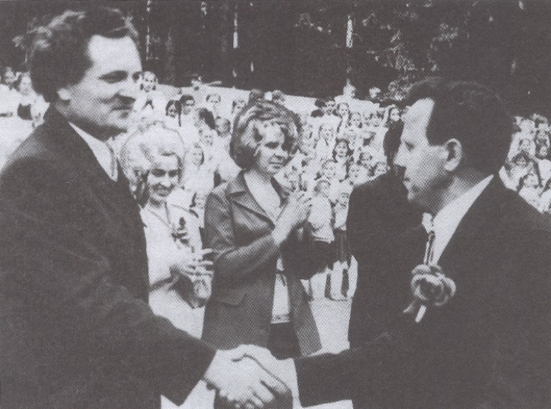 Rajoninė dainų šventė 1974 m. Kultūros skyriaus vedėjas A. Šidlauskas (kairėje) įteikia apdovanojimą Kvėdarnos kultūros namų mišraus choro vadovui Zenonui Valantiejui Vlado GAUDIEŠIAUS nuotr. (Iš monografijos „Kvėdarna)