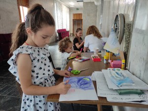 Humanitarinės pagalbos centre pabėgėlių vaikai skatinami piešti, tikintis, kad taip už­mirš patirtus sukrėtimus
