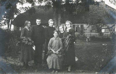 Rimkų šeima prie namo Pašlynio k. 1934 m.: mama Uršulė Kungytė-Rimkienė (sėdi), vaikai Uršulija, Antanas, subdiakonas Stasys, Kristina, Ju­lijona (stovi)