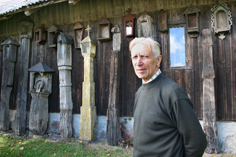 K. Lovčikas prie paties surinktų koplytstulpių Upynos liau­dies amatų muziejuje